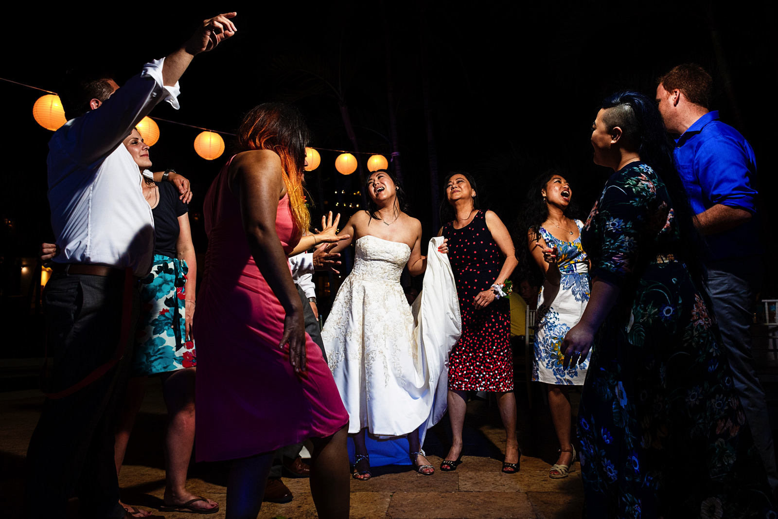 Bride and mom dance in group with other wedding guests