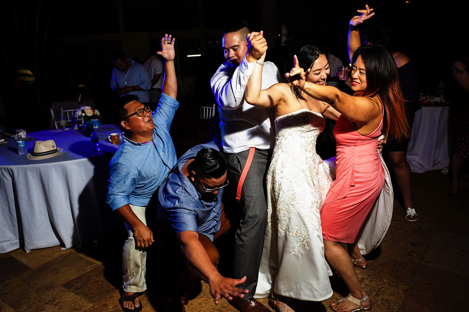 Wedding guests do a sandwich dance with groom and bride in the middle