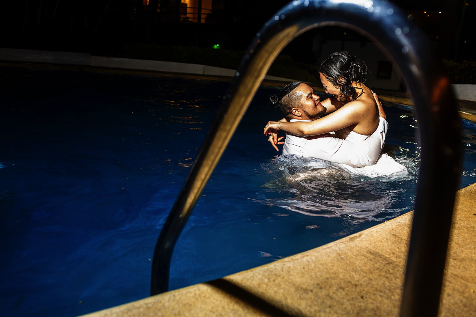 Bride and groom inside the hotel pool at the end of their destination wedding day