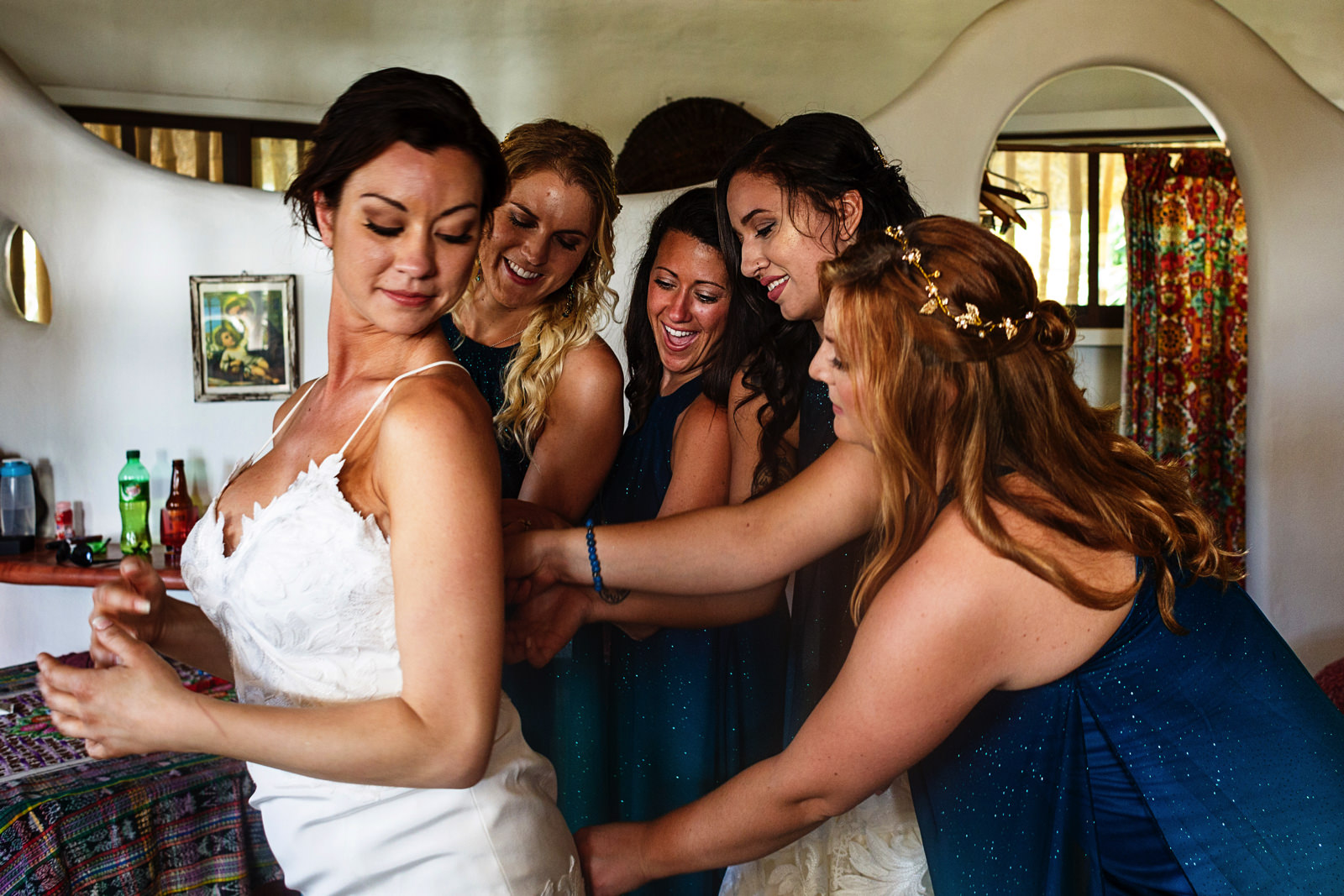 All bridesmaids helping the bride with the wedding dress
