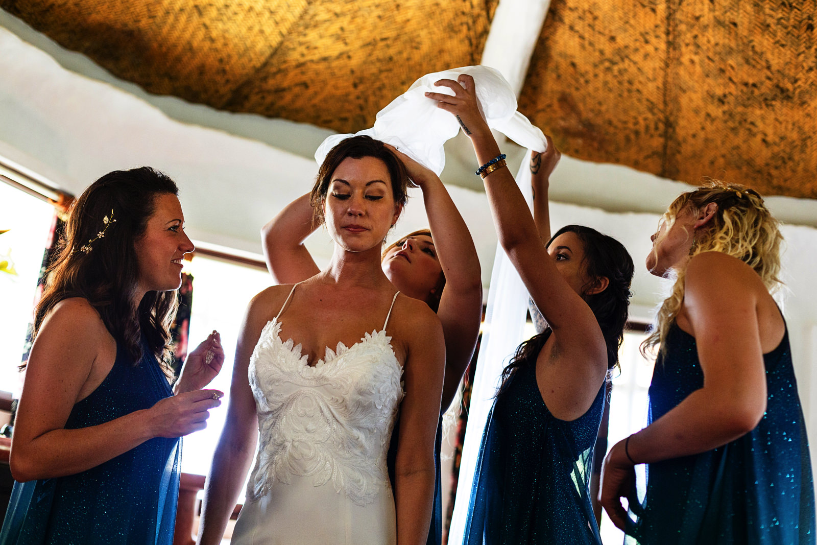 Bridesmaids helping the bride to put on the wedding veil
