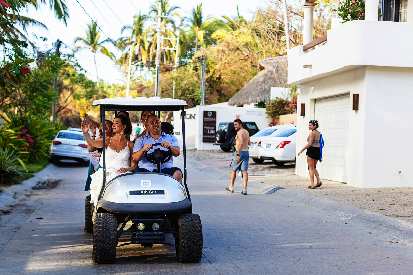 Bride and bridesmaids rolling on the streets of Sayulita in a golf cart towards the wedding ceremony