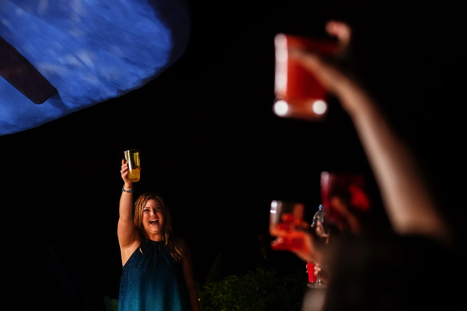 Bridesmaid toast and raised hands with red drinks