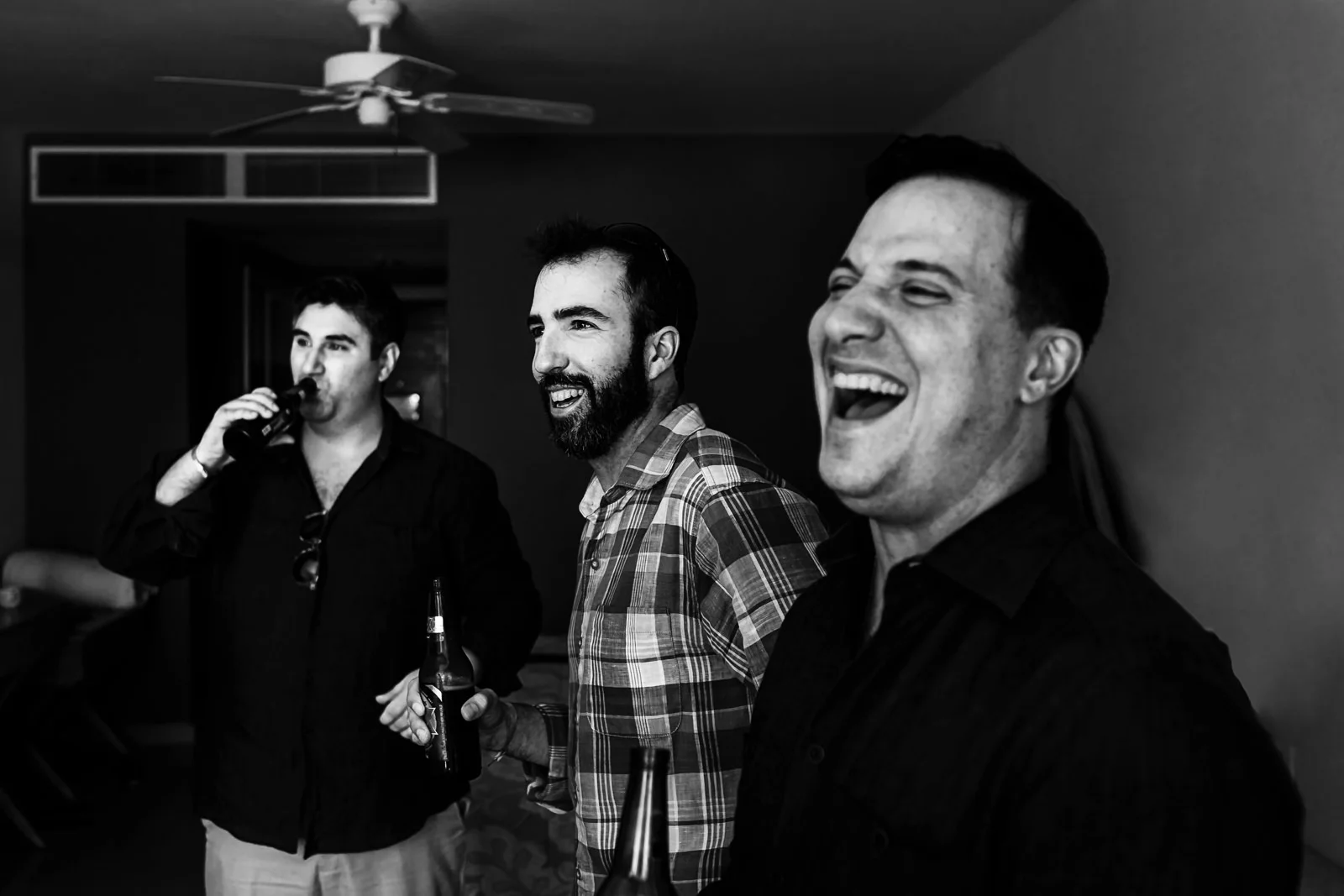 Groom and groomsmen enjoying beers and sharing a laugh at an Iberostar Punta Mita room