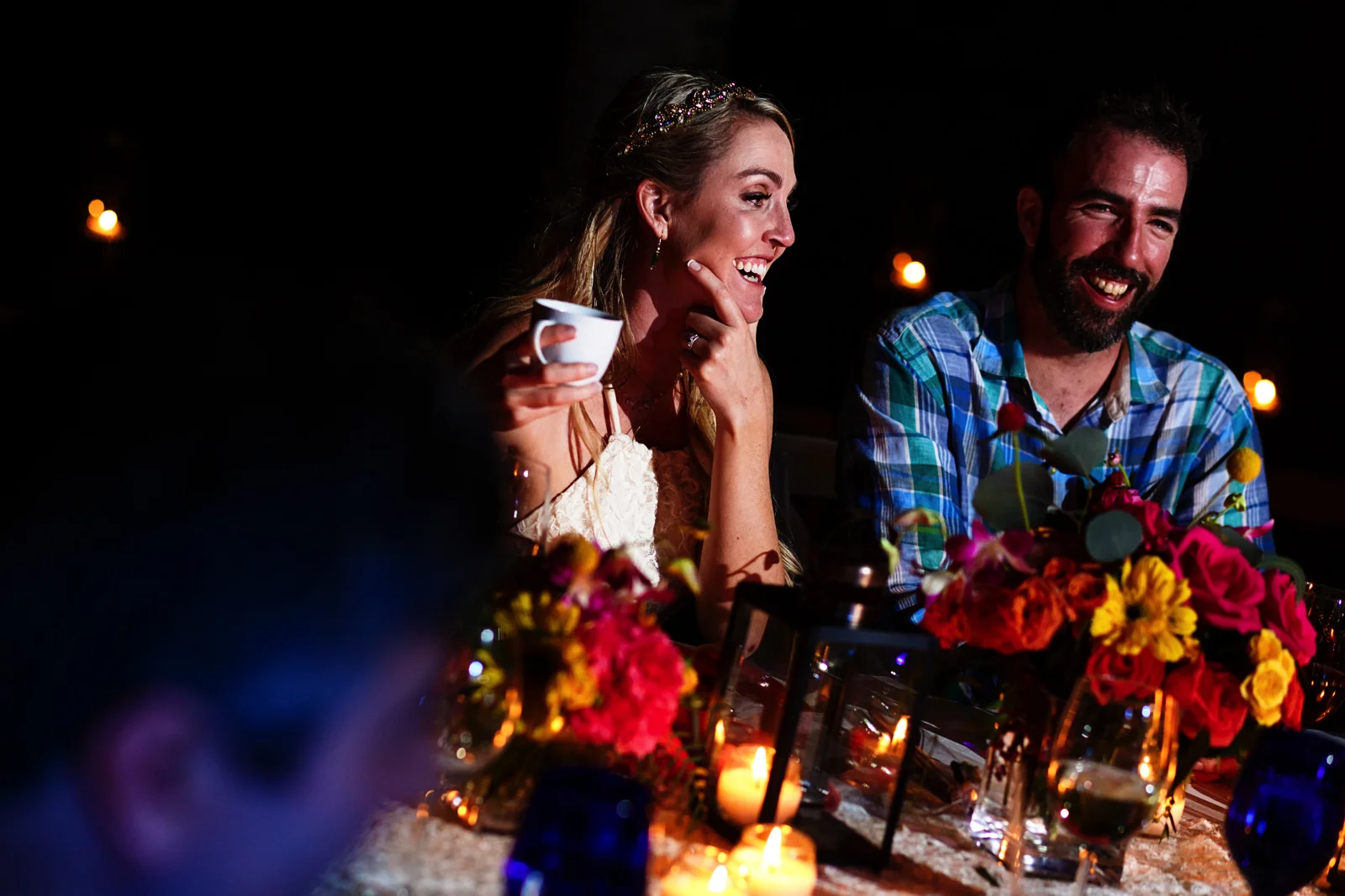Bride and groom laugh during wedding dinner speeches