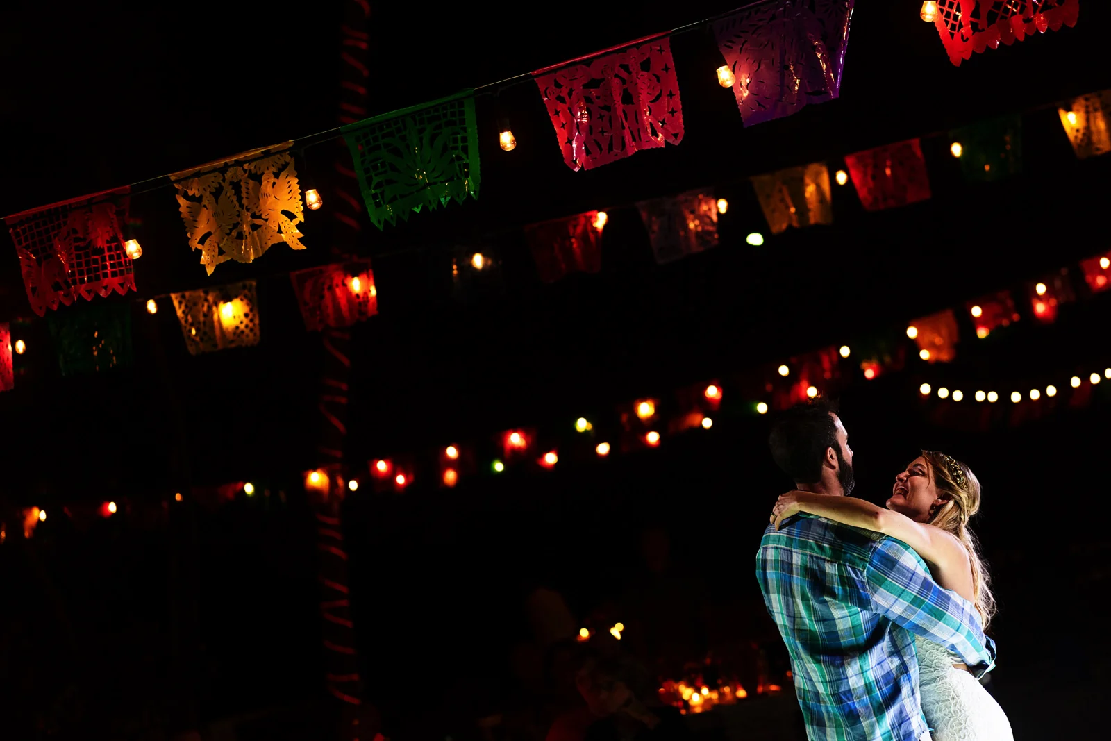 Bride and groom first dance under papel picado decoration