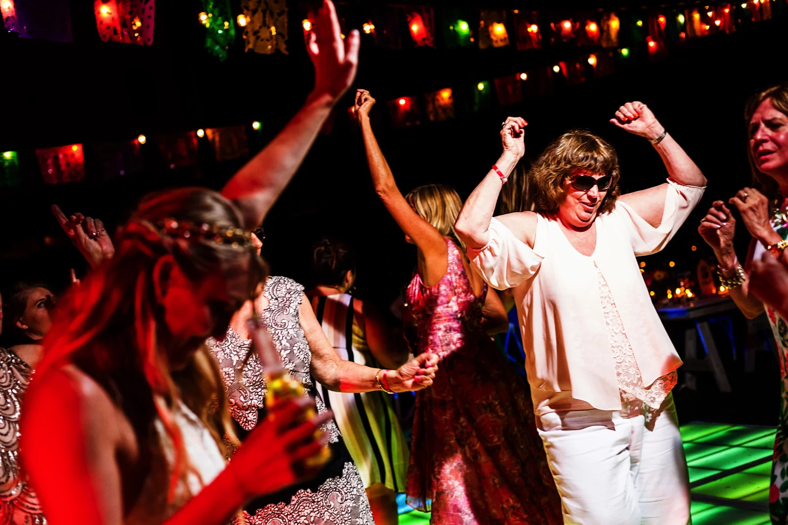 Bride and wedding guests dancing over the illuminated dance floor
