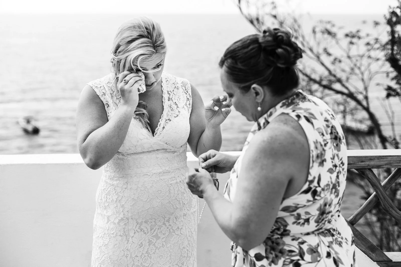 Bride crying after giving a bracelet to her mother.