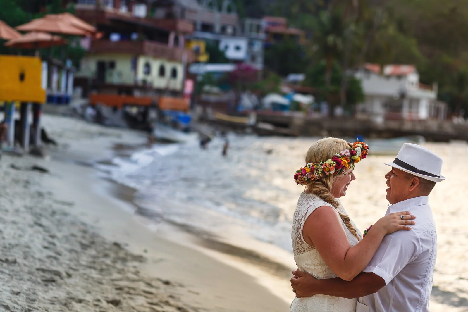 Bride and groom portrait on Yelapa’s beach with a view in the background of the town houses.
