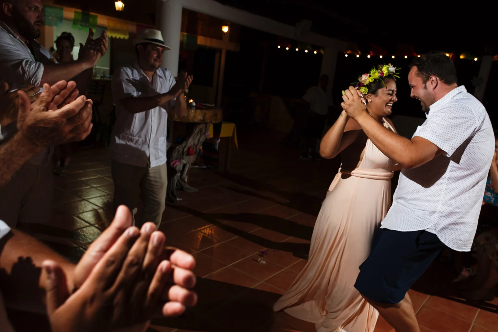 Wedding guests clapping to the dancing couple.