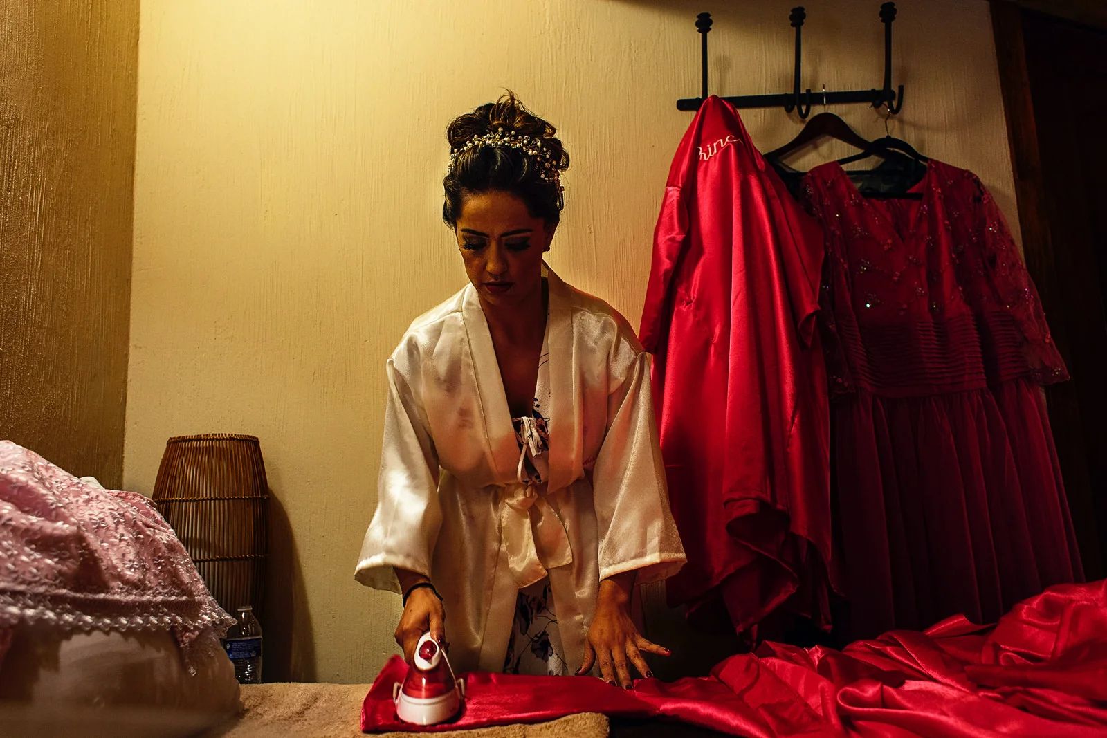 Bride irons the bridesmaids robes before anyone arrives to her bedroom.