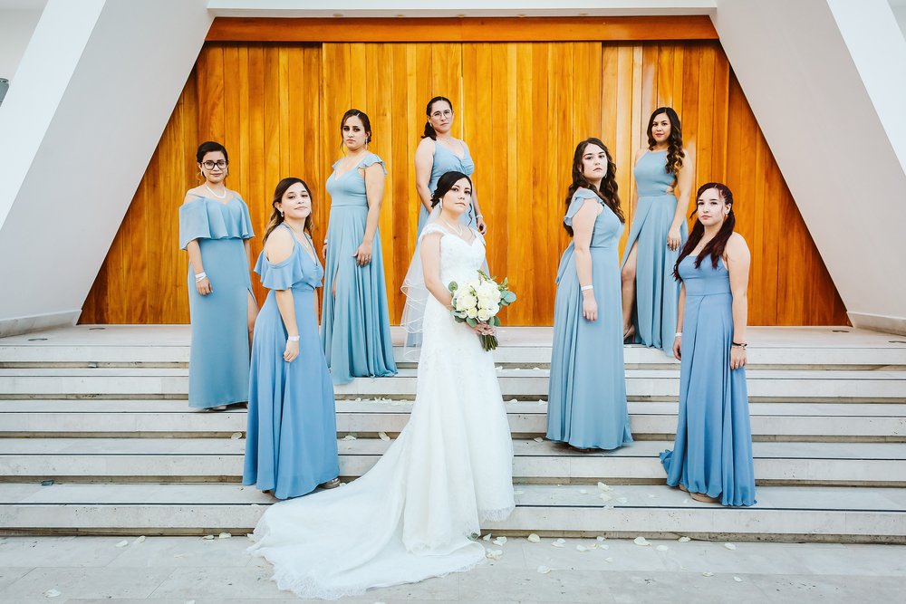 Bride and bridesmaids pose at the staircase outside the chapel