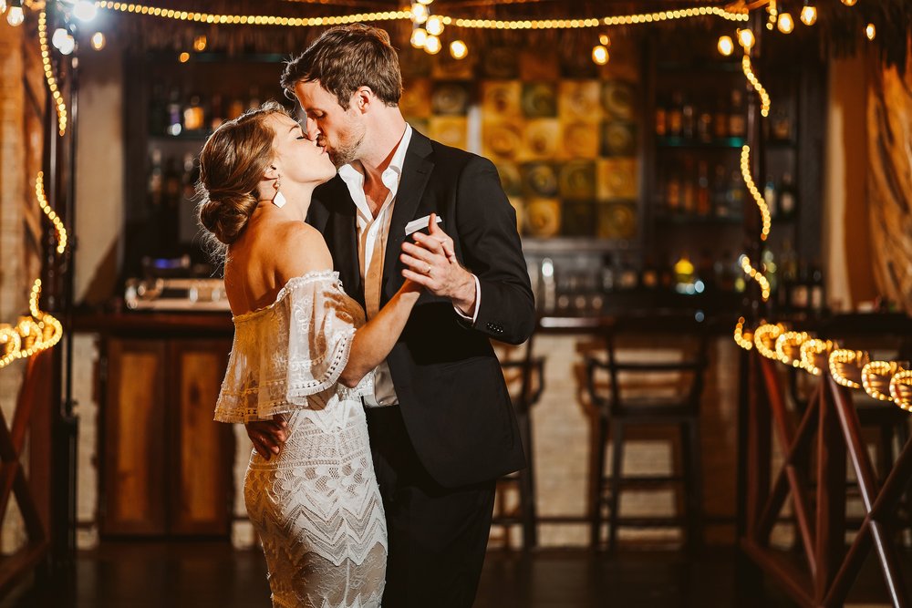 Bride and groom kiss during their first dance as a married couple