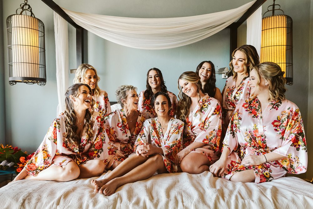 Bride and bridesmaids having fun on the bed for a portrait