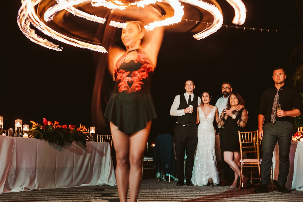 Groom and bride enjoy the fire dancer at the wedding reception in Casa Karma