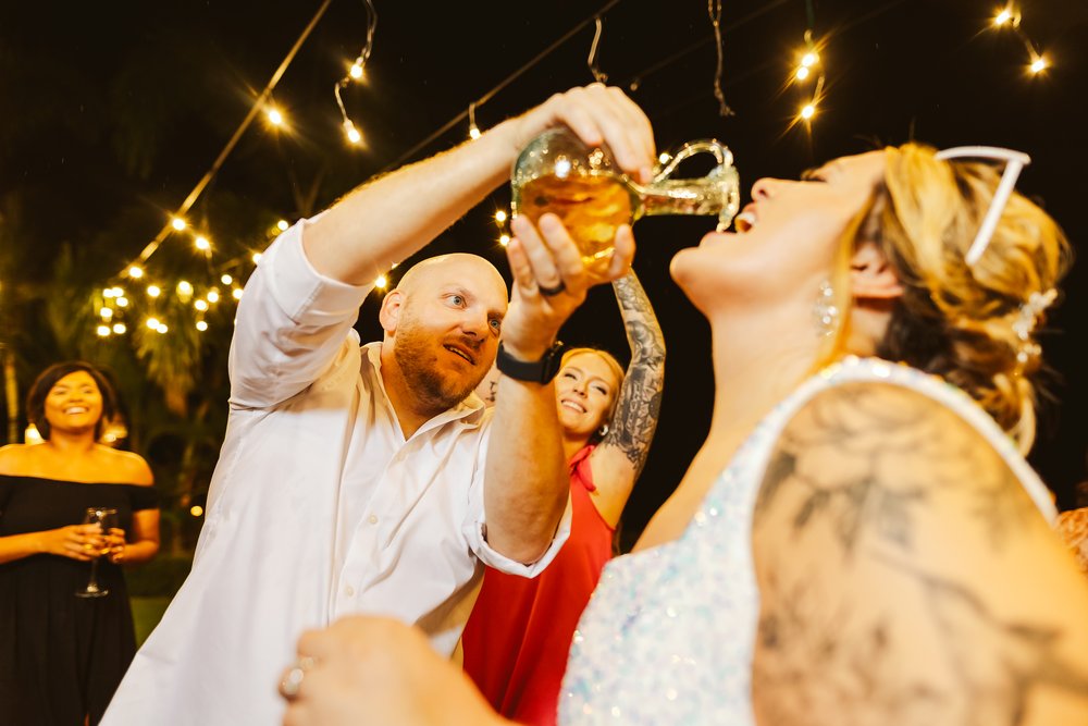 Wedding guest pours tequila straight from the bottle to the bride during the party at Hacienda Antigua, in Lo De Marcos, NAY.