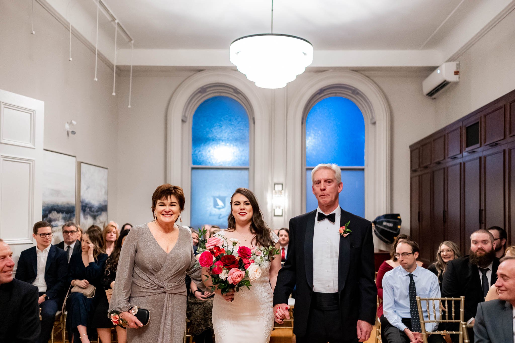 Bride walking down the Halifax Club Aisle with mom and dad