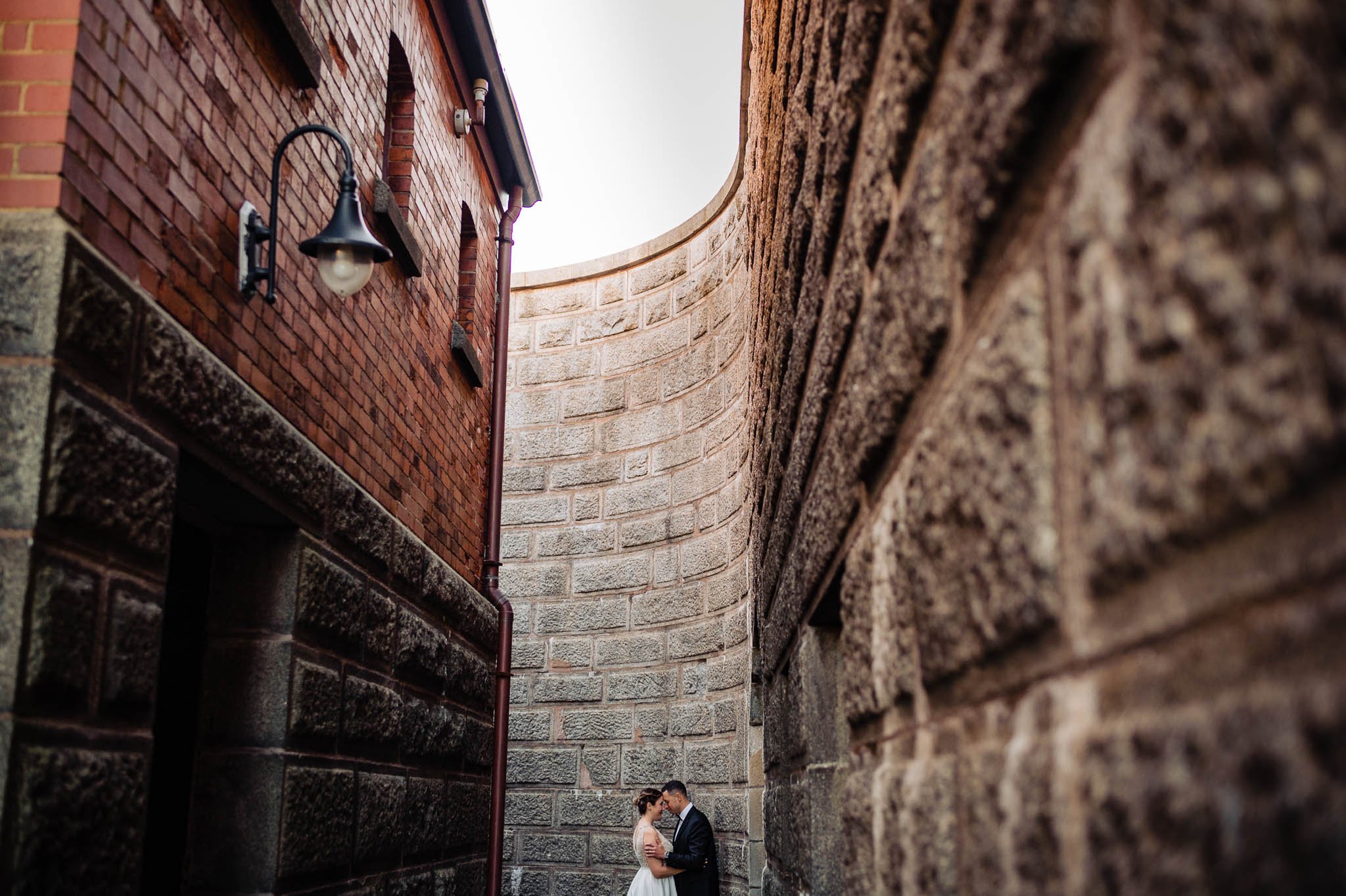 Bride and Groom holding each other in  Citadel Hill with brick walls taking up whole frame