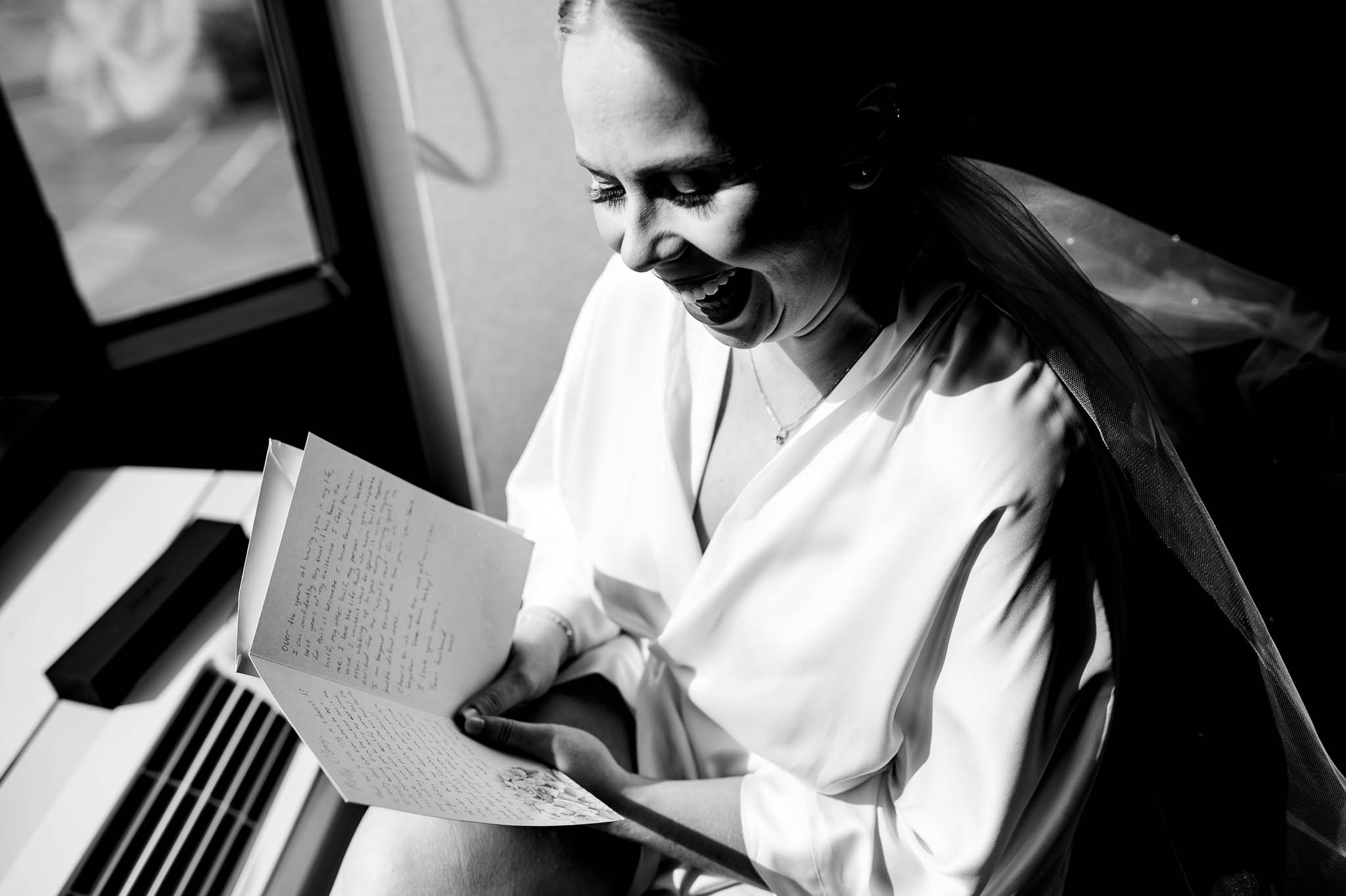 bride in b&amp;w photo reading love letter from groom 