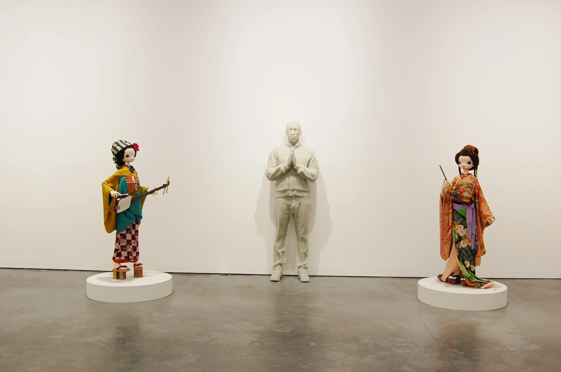 Daniel Arsham's broken glass and resin sculpture modeled with Pharrell's own body is flanked by two Chiho Aoshyma's sculptures 