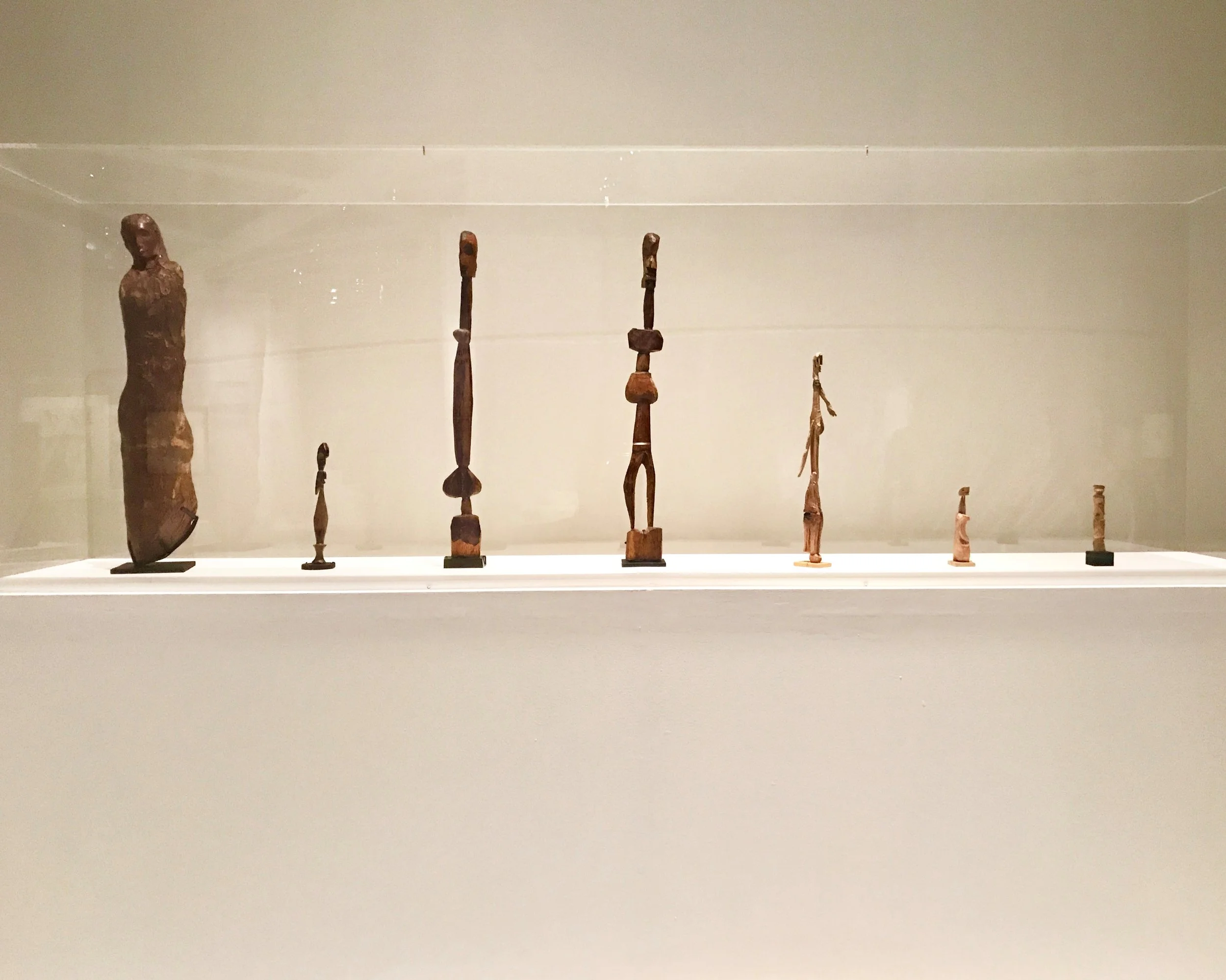 The sculpture on the left is Pablo Picasso's Buste de Femme (Fernande), 1906 the other ones to the right are by anonymous African artists.