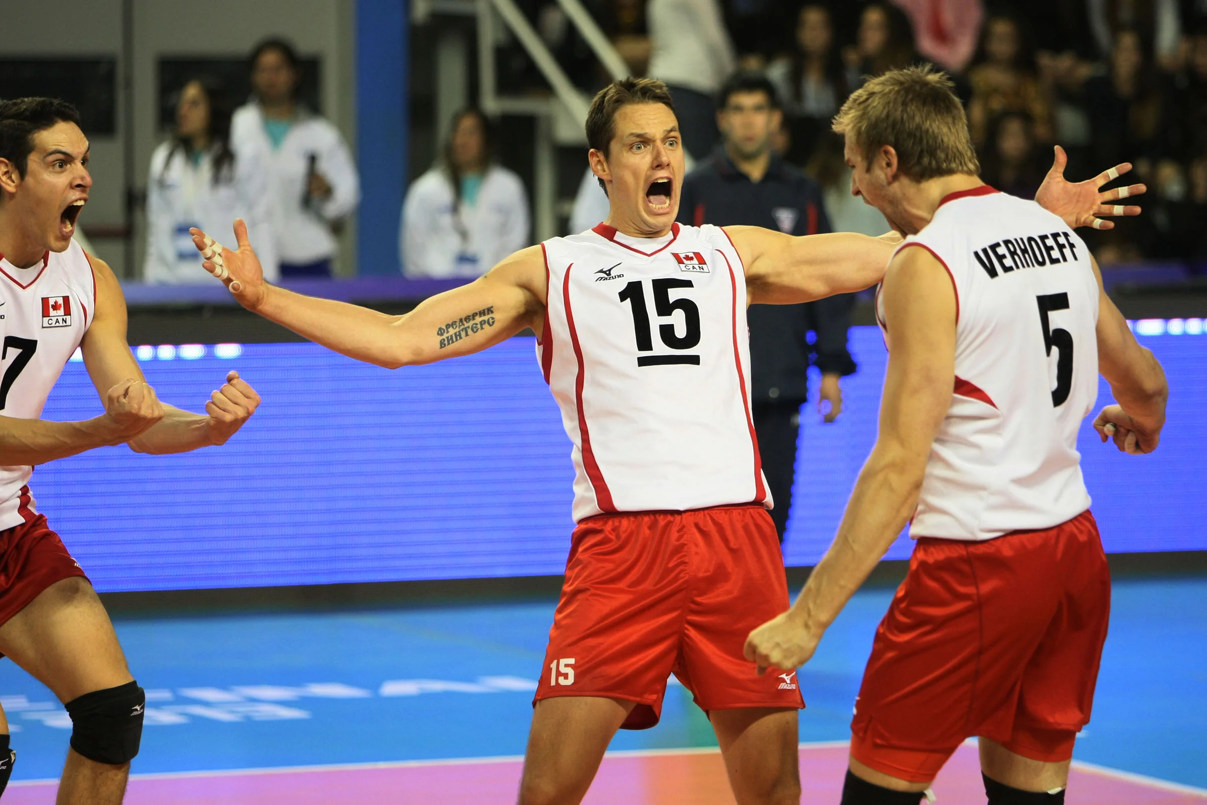 Canada's Dallas Soonias, Fred Winters, and Rudy Verhoeff celebrate a point against Russia. Photo: FIVB