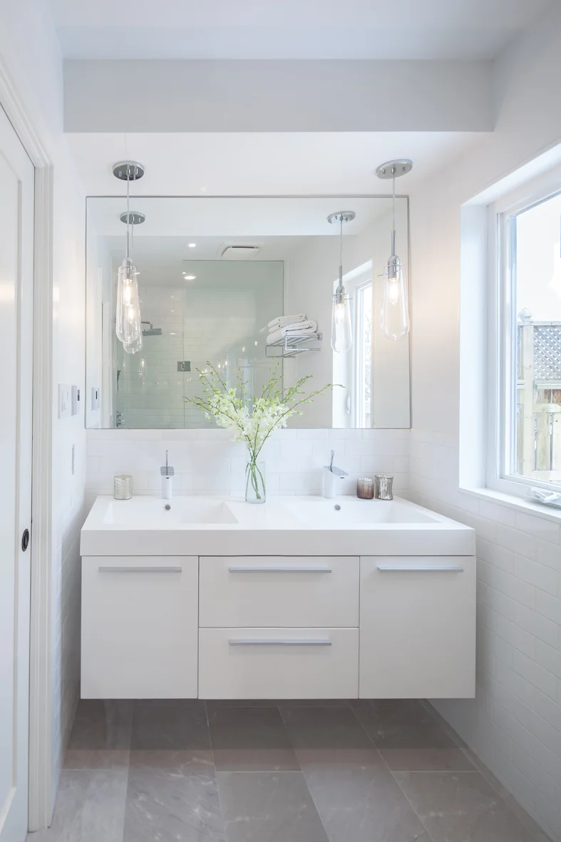 Glass pendants, wall to wall mirror and suspended vanity come together to create an elegant and bright ensuite