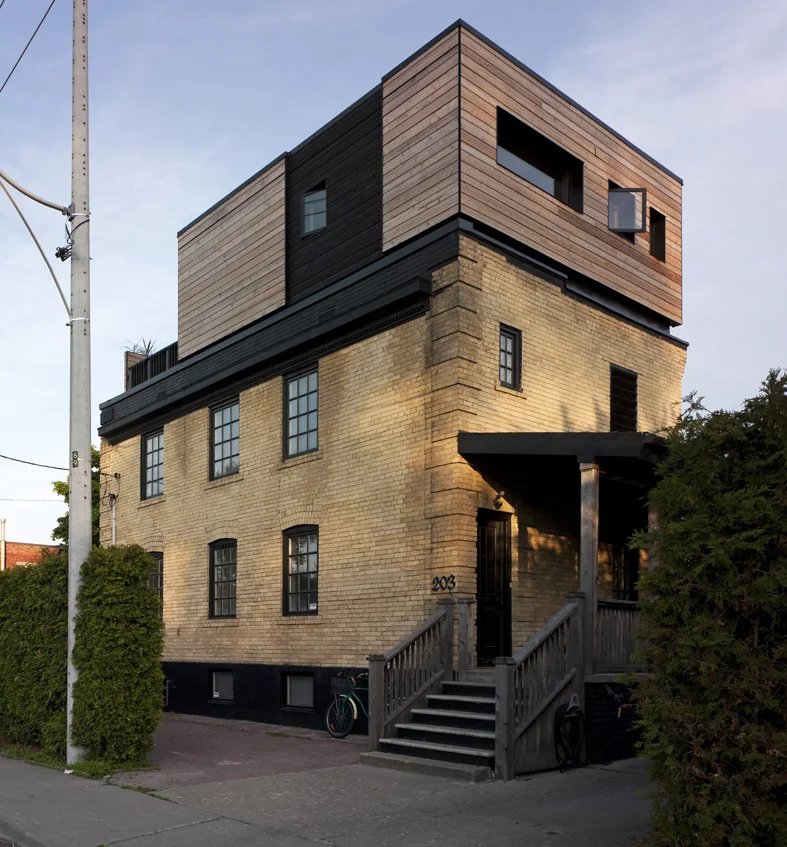 Original brick coach-style house with new cedar-clad addition