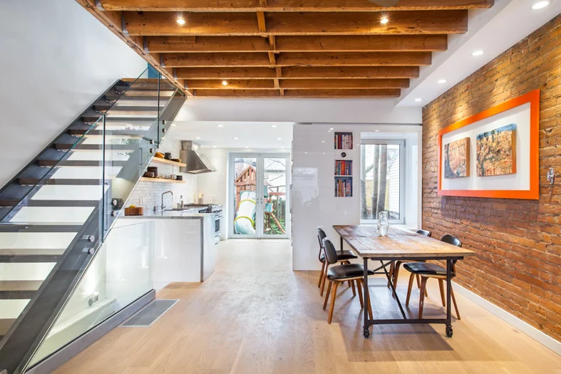 The new sleek materials were carefully composed to juxtapose the warm brick wall and exposed wood ceiling joists, creating a harmonious balance of old and new