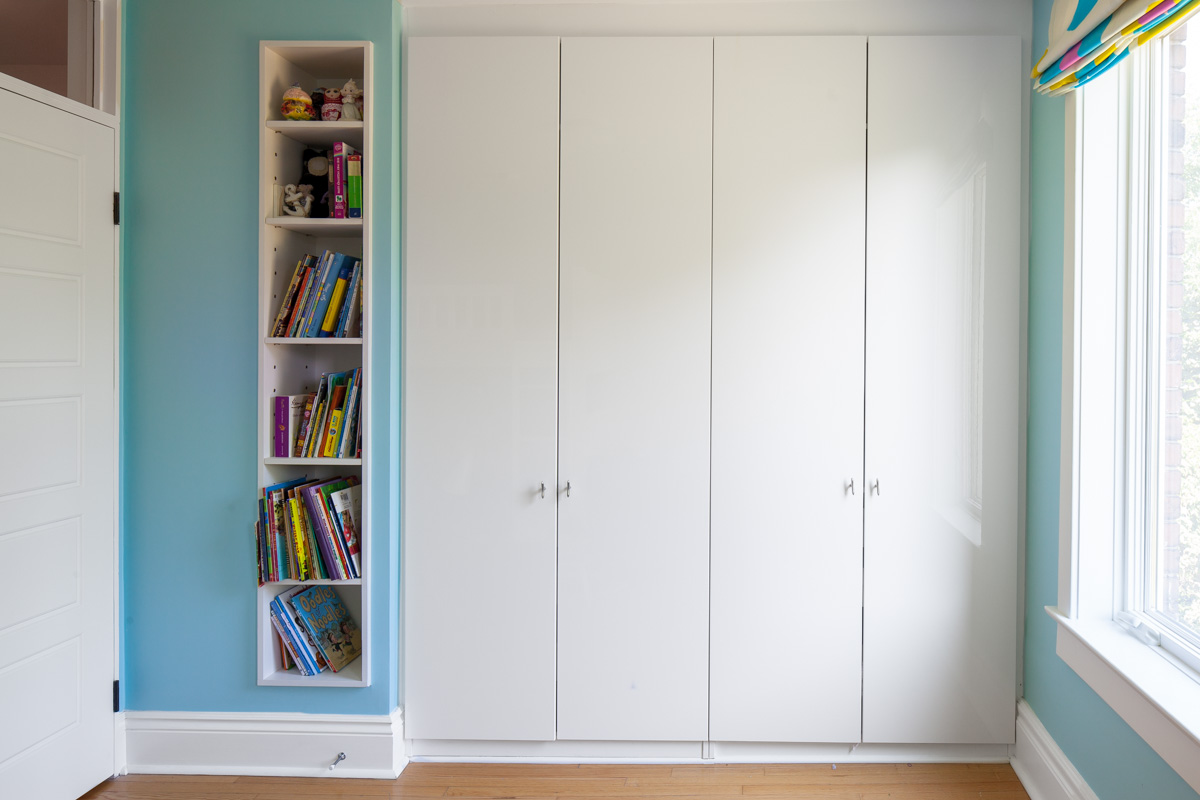 Custom storage built into the wall complements built-in IKEA wardrobes to maximize available storage in the bedroom.