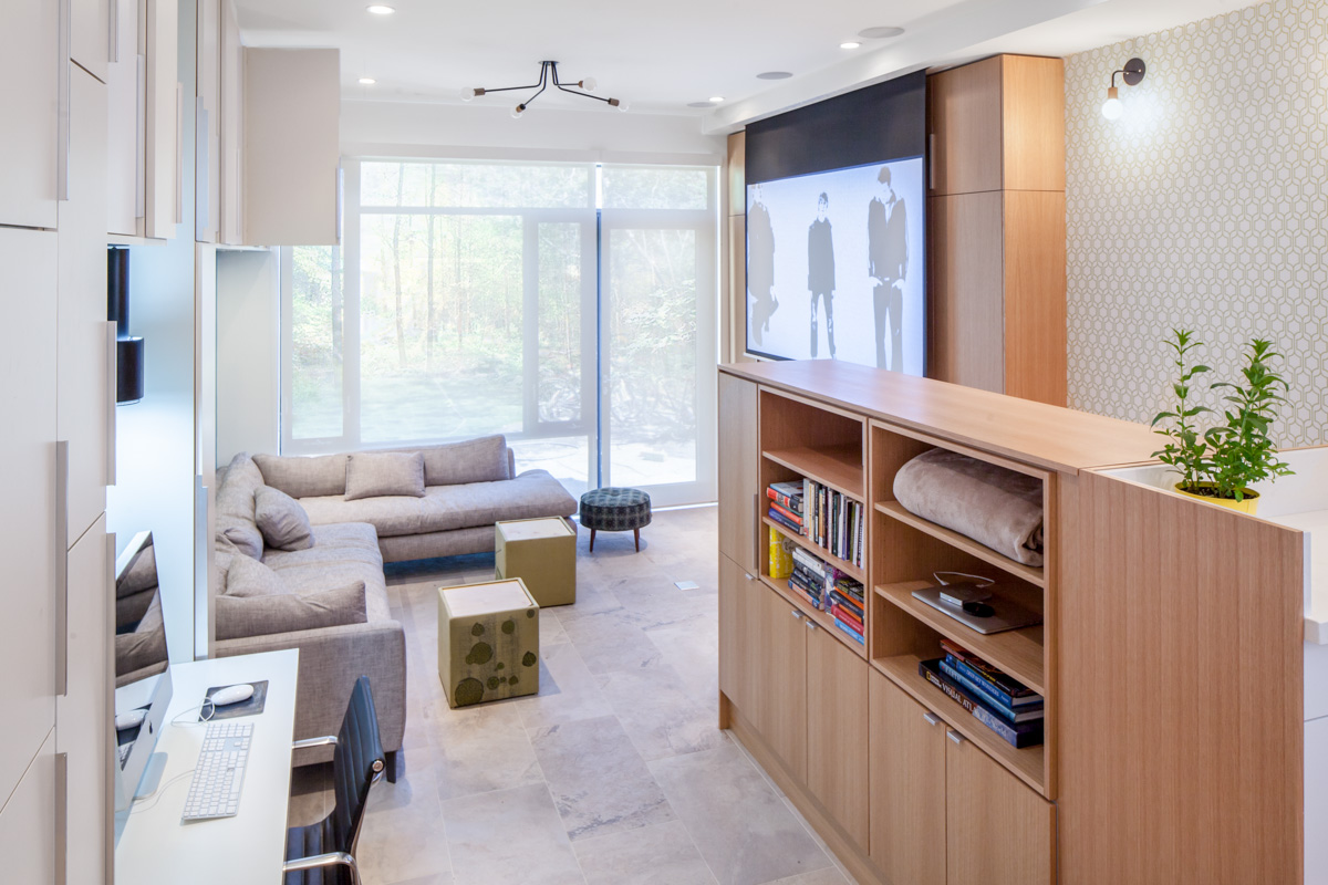 The living room can transform into a family theatre for movie nights with a retractable screen, projector, and recessed speakers.