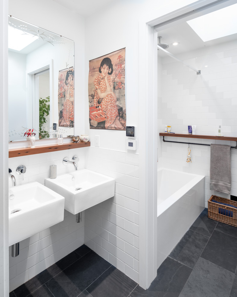 The bathroom sinks are separated from the toilet and shower by a sliding door so as to allow a family of 4 to most efficiently use the space of a single bathroom. A water-resistant redwood shelf ties the two rooms together and allows for storage of various products around the bathroom.