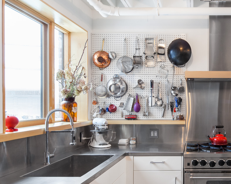 Drawing from one of the owner's experience as a chef, the kitchen is inspired by a commercial kitchen crossed with the honest functionality of Julia Childs' workspace. Walls of durable metal pegboard embody the project's authentic approach in which the tools of everyday life are displayed as objects, while simultaneously making kitchen utensils convenient to use.