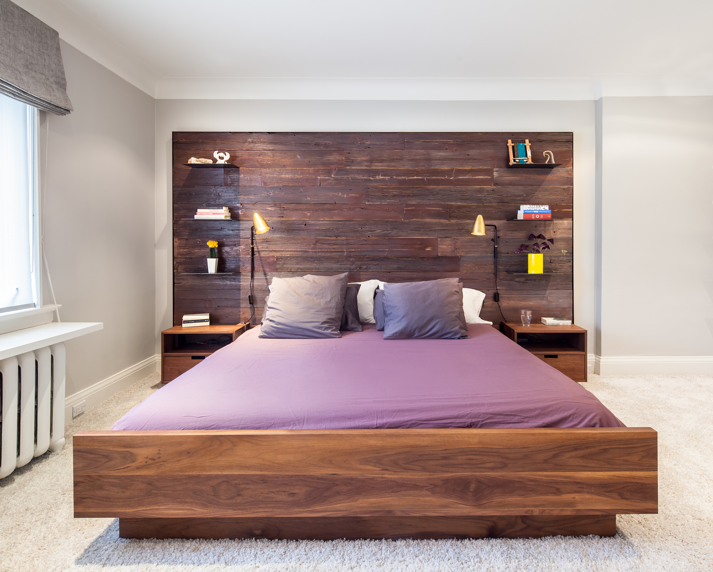 The master bedroom is a combination of rich textured surfaces such as a reclaimed wood feature wall, designed in collaboration with Commute Home (fabrication by Commute Home) and thick carpet, with sleek contemporary details in metal and walnut.