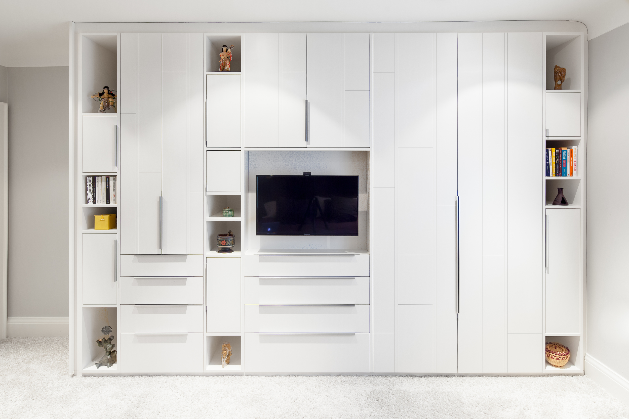 A custom wardrobe wall in the master bedroom makes an elegant statement with niches to accommodate the couple’s collection of unique aboriginal art.