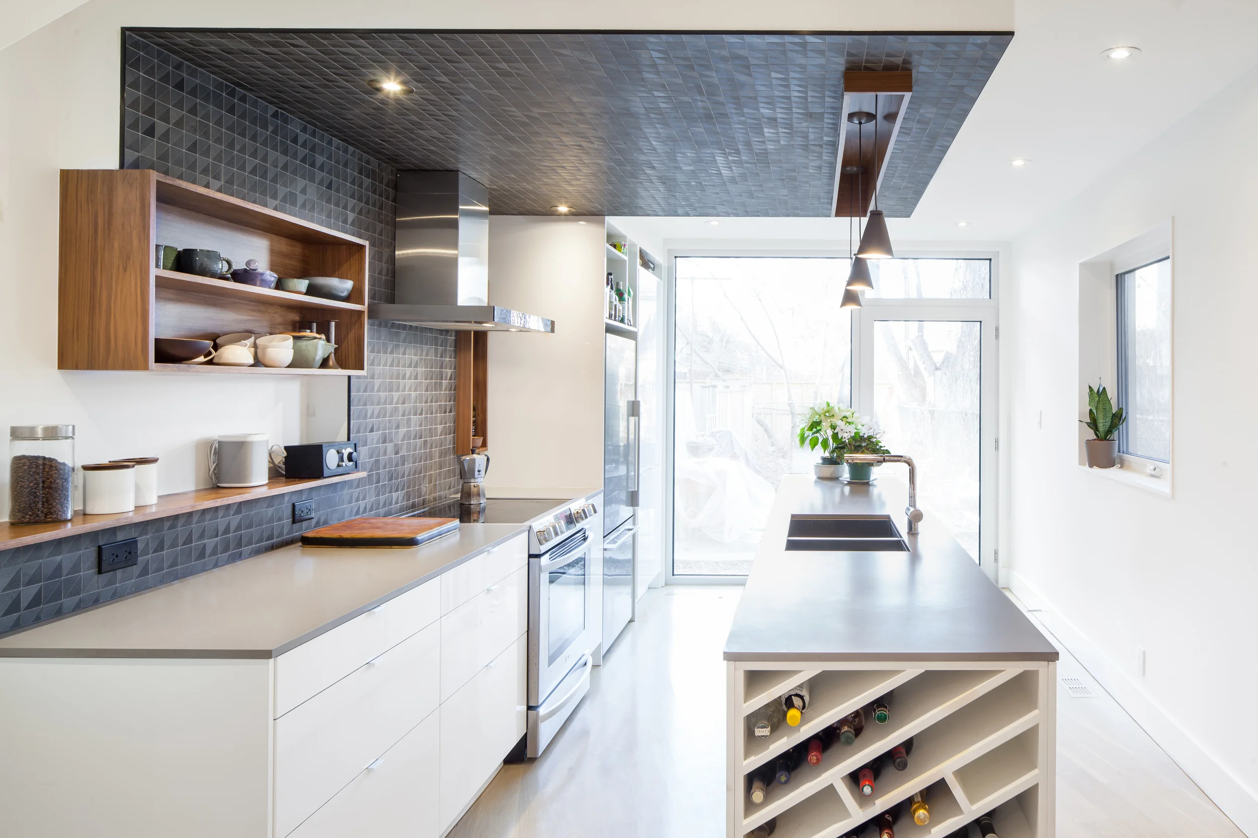 A large new window at the back of the house floods the home with natural light. The custom angled wine storage shelves at the end of the island subtly picks up on the angle of the floor.