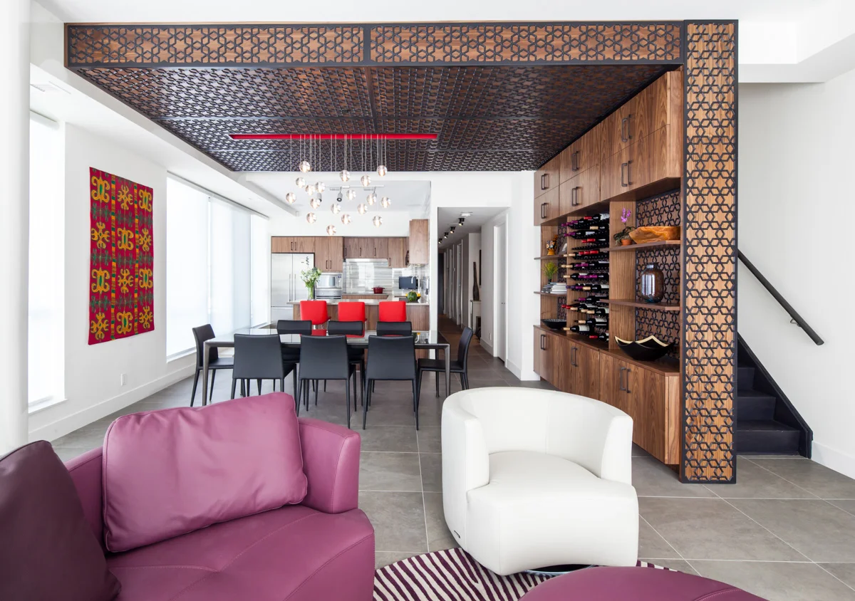 The focal point of main living space is a feature millwork wine storage wall that wraps onto the ceiling to help spatially define the dining area as a space separate, but connected to the kitchen, and living room on either side. While the overall gesture within the space is simple and bold, the intricate geometric patterns draw abstract inspiration from the couple’s ethnic heritage.