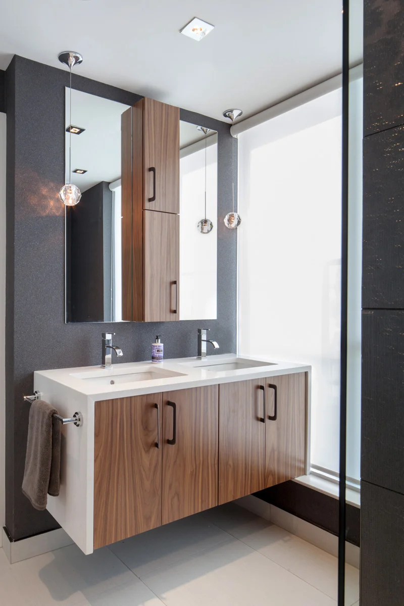 The ensuite accommodates a double vanity with a semi-recessed walnut medicine cabinet between the two sinks, with one door opening in each direction, for him and for her.
