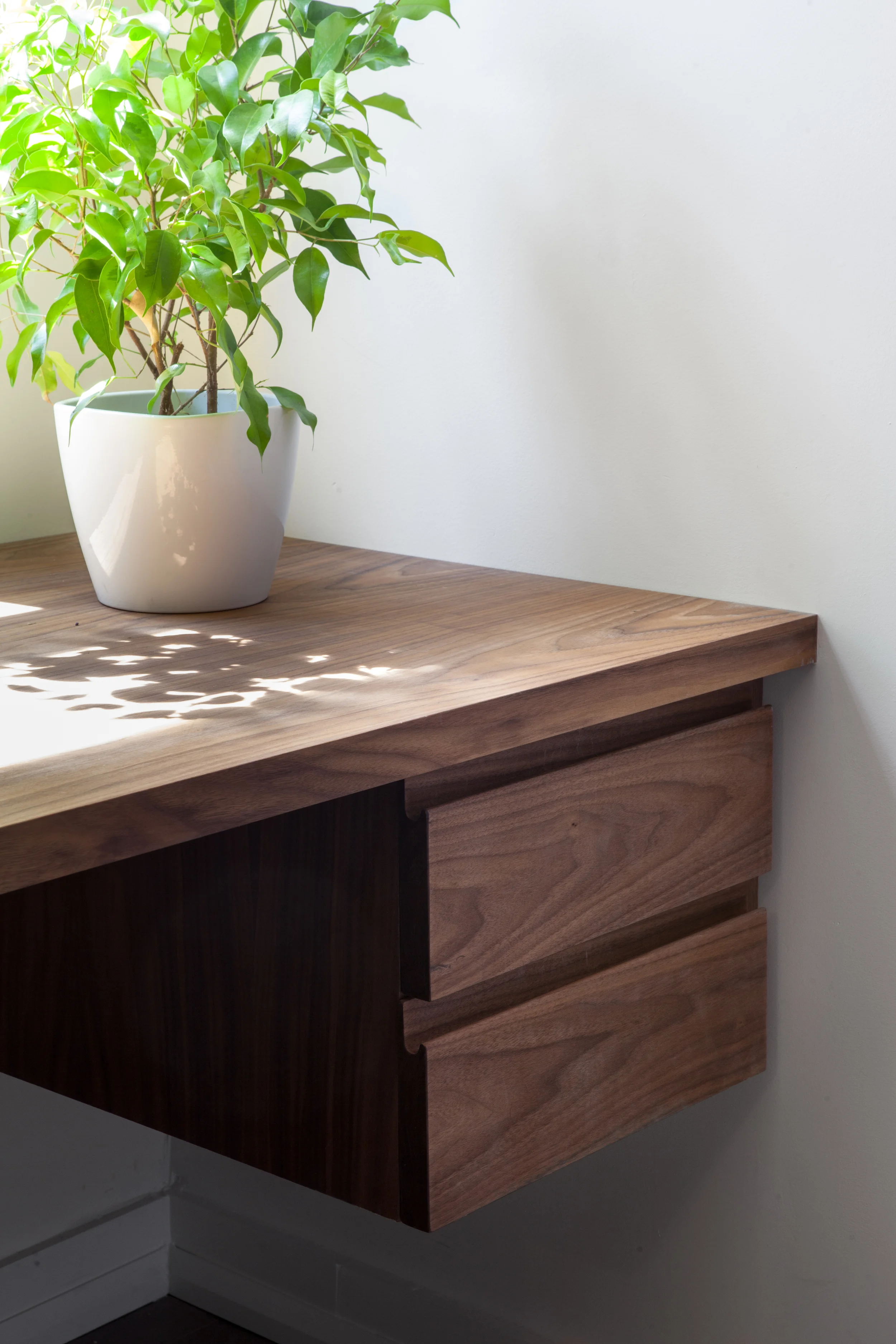 Integrated drawer pulls, milled from solid walnut drawer fronts, are a subtle, elegant detail