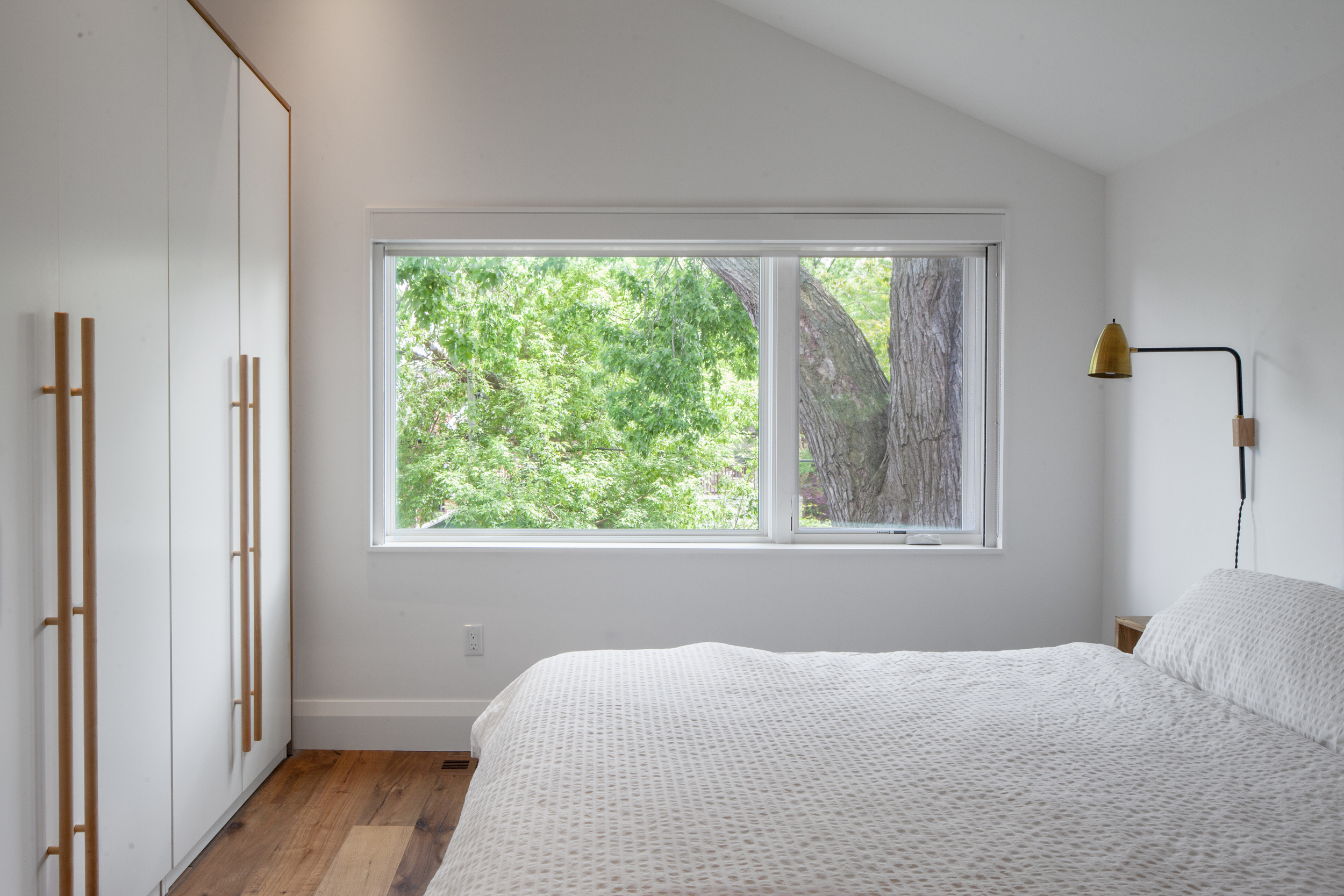 An enlarged window transforms the room into something of a serene, modern treehouse..