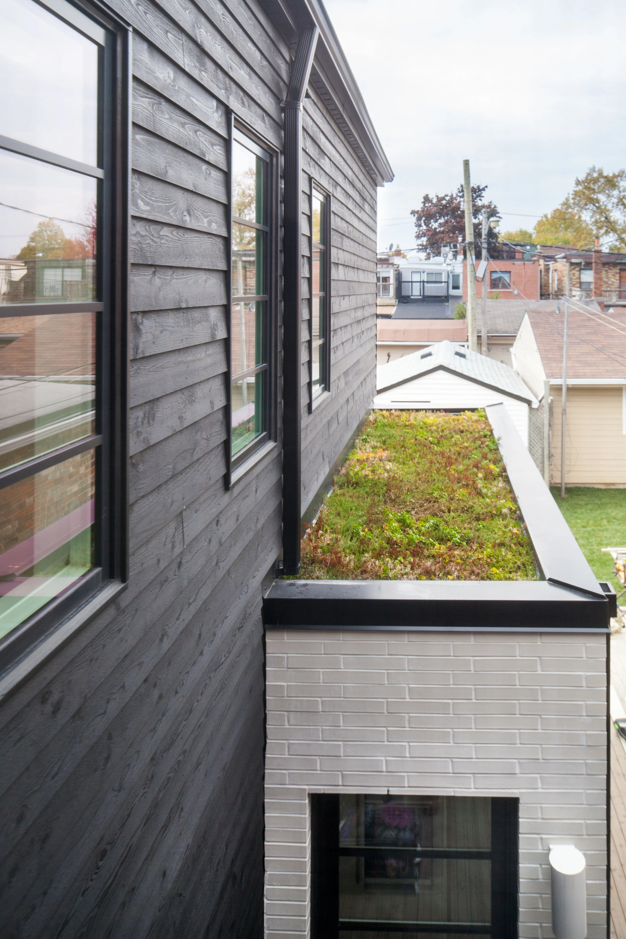 The addition is designed to maintain light and views from an existing bedroom in the house; where the second floor steps back, a portion of roof is covered in a low-maintenance green roof system that improves views for the homeowners and their neighbours.