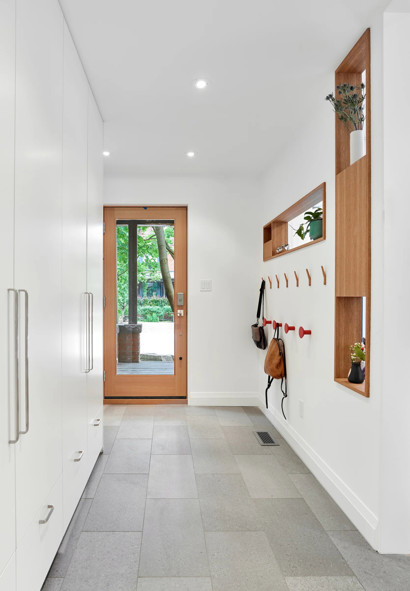 The front foyer offers generous amounts of closet space and open shelves that allow visitors a sneak peak into the living space beyond.