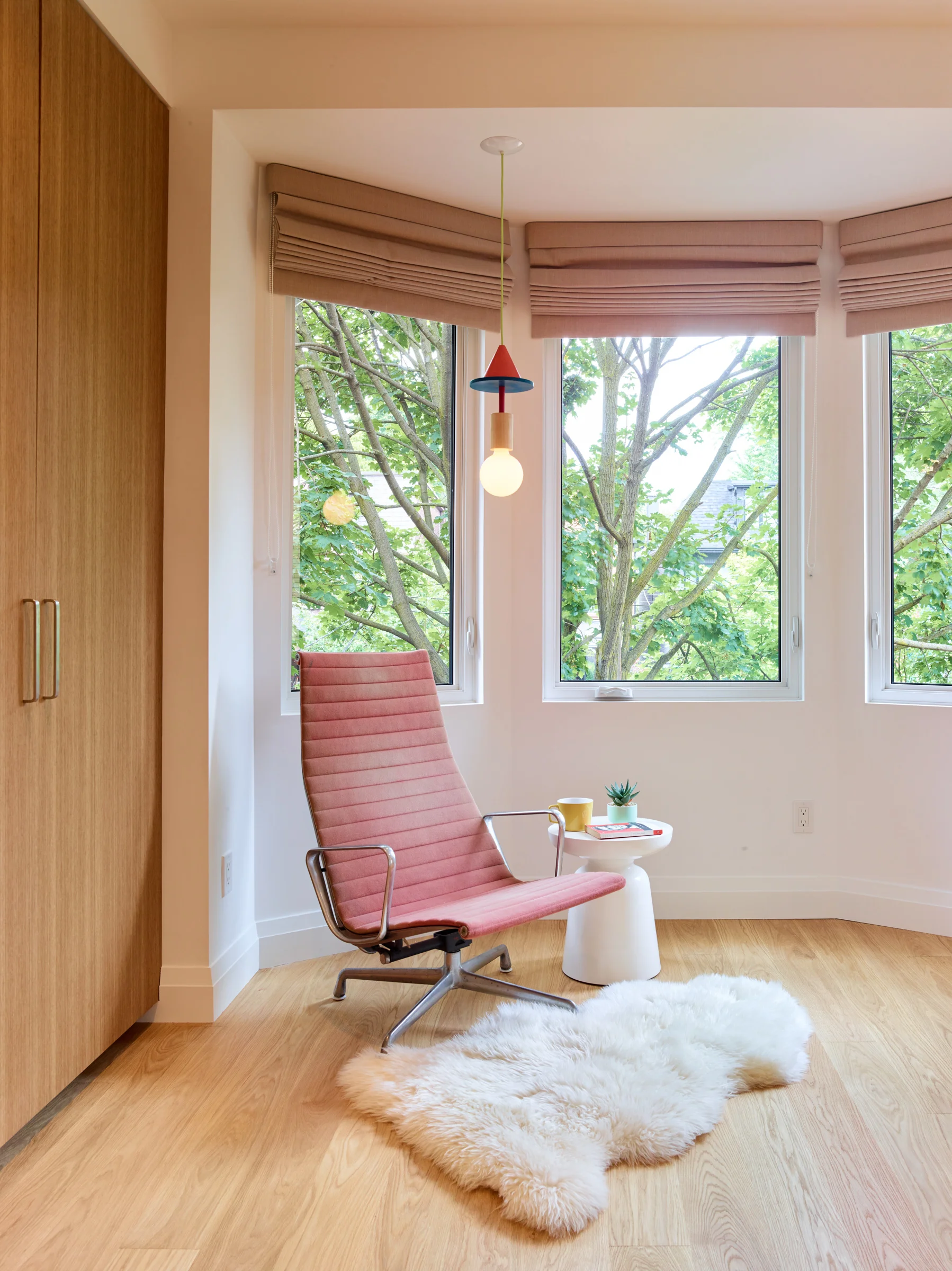 In the kids bedroom at the front of the house, a playful light fixture hangs in the bay window; the colours and shapes chosen by the girls during the design process.
