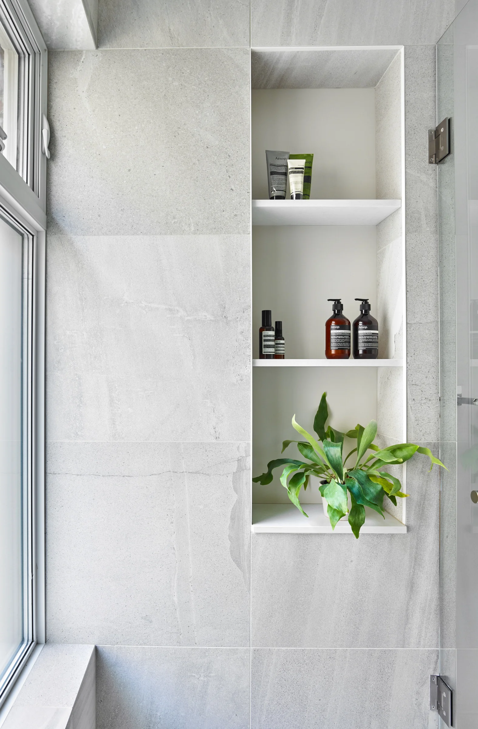 Niche shelves provide plenty of space for storing shampoos and other shower products.