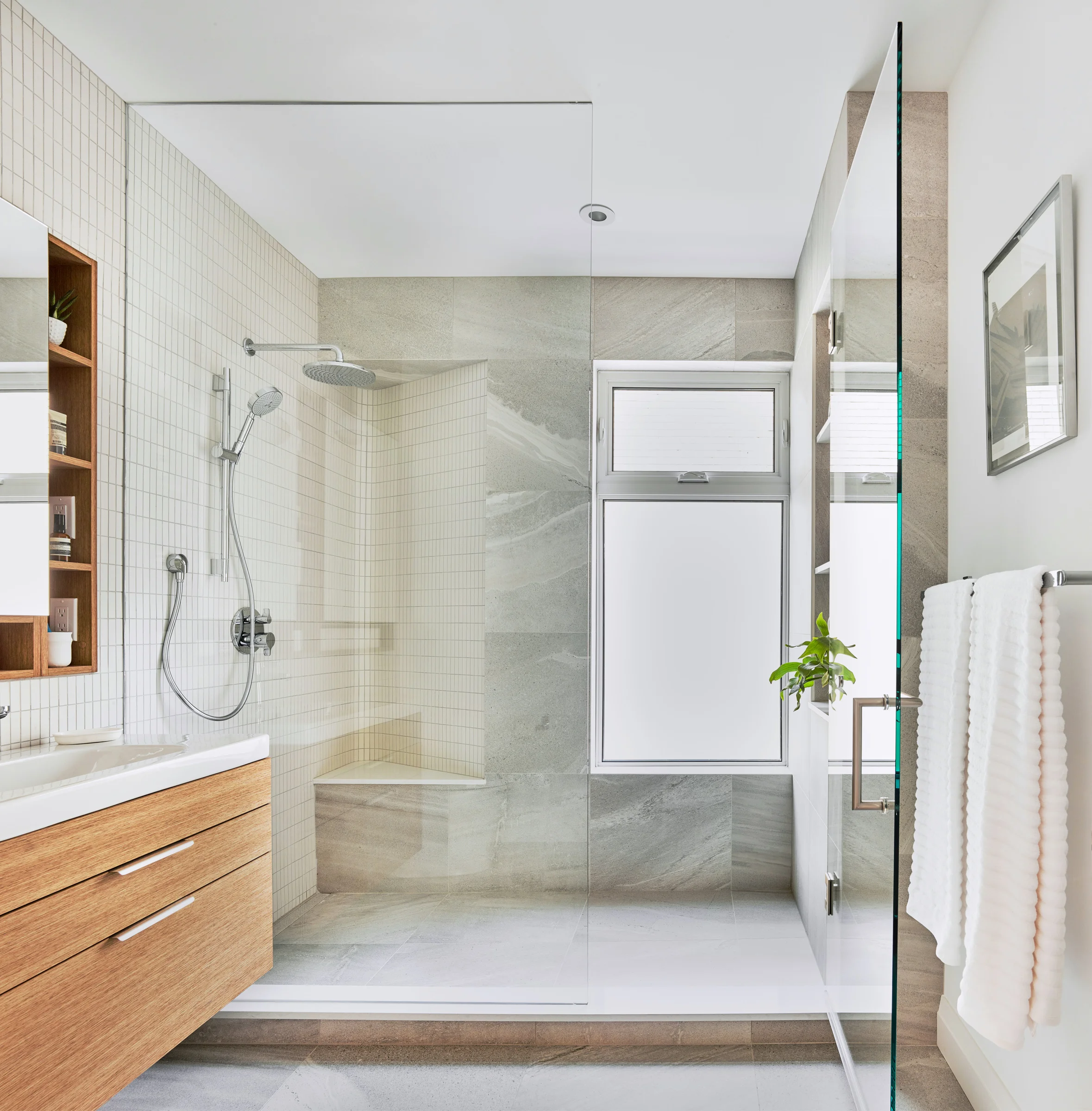 The main bathroom features variations on the material theme of white & wood; a textured floor tile wraps up the wall in shower.