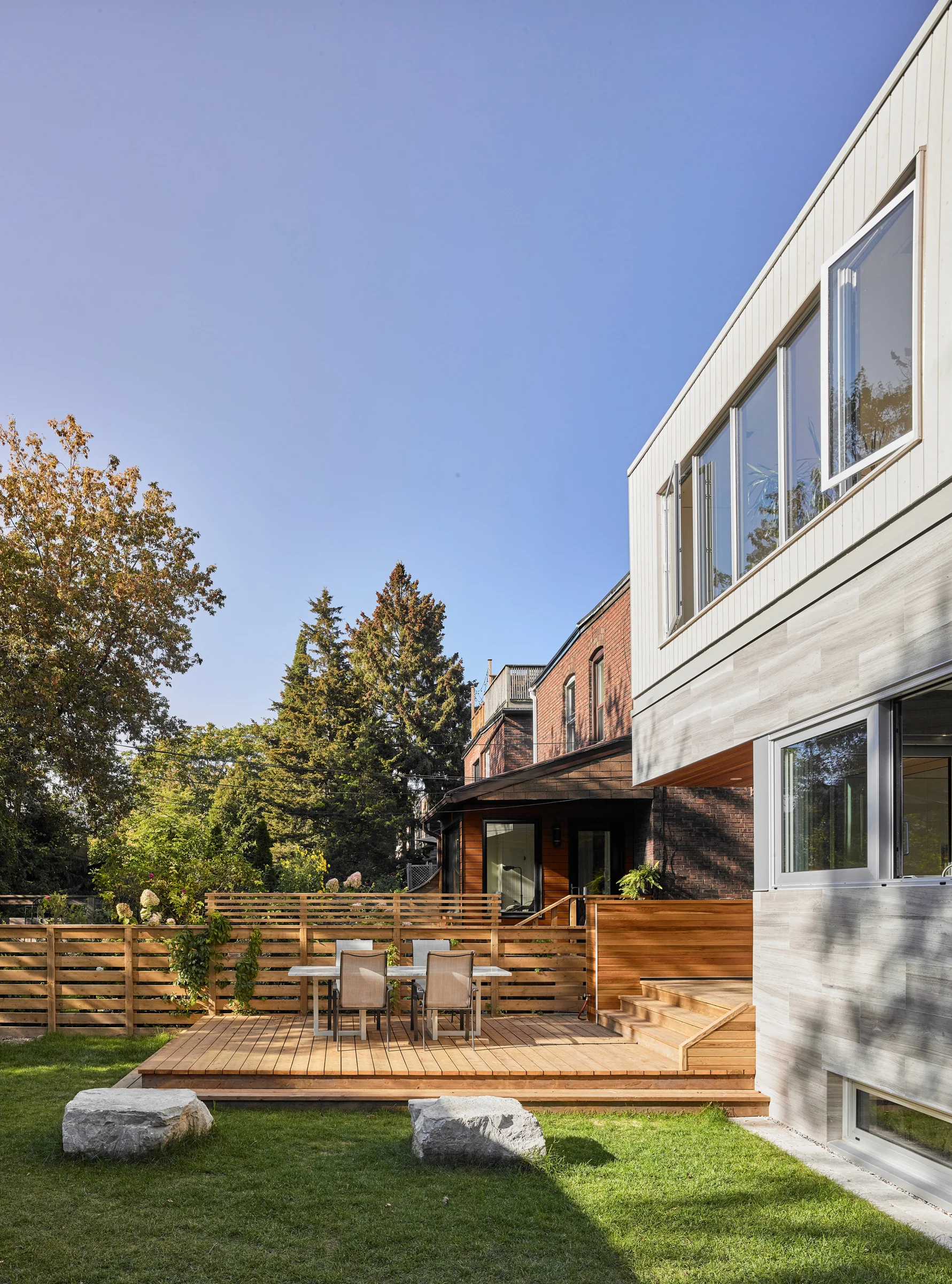 The deck provides a spot for outdoor dining; fences are carefully considered to provide the desired degree of privacy at the dining table, without completely blocking views between neighbouring yards.