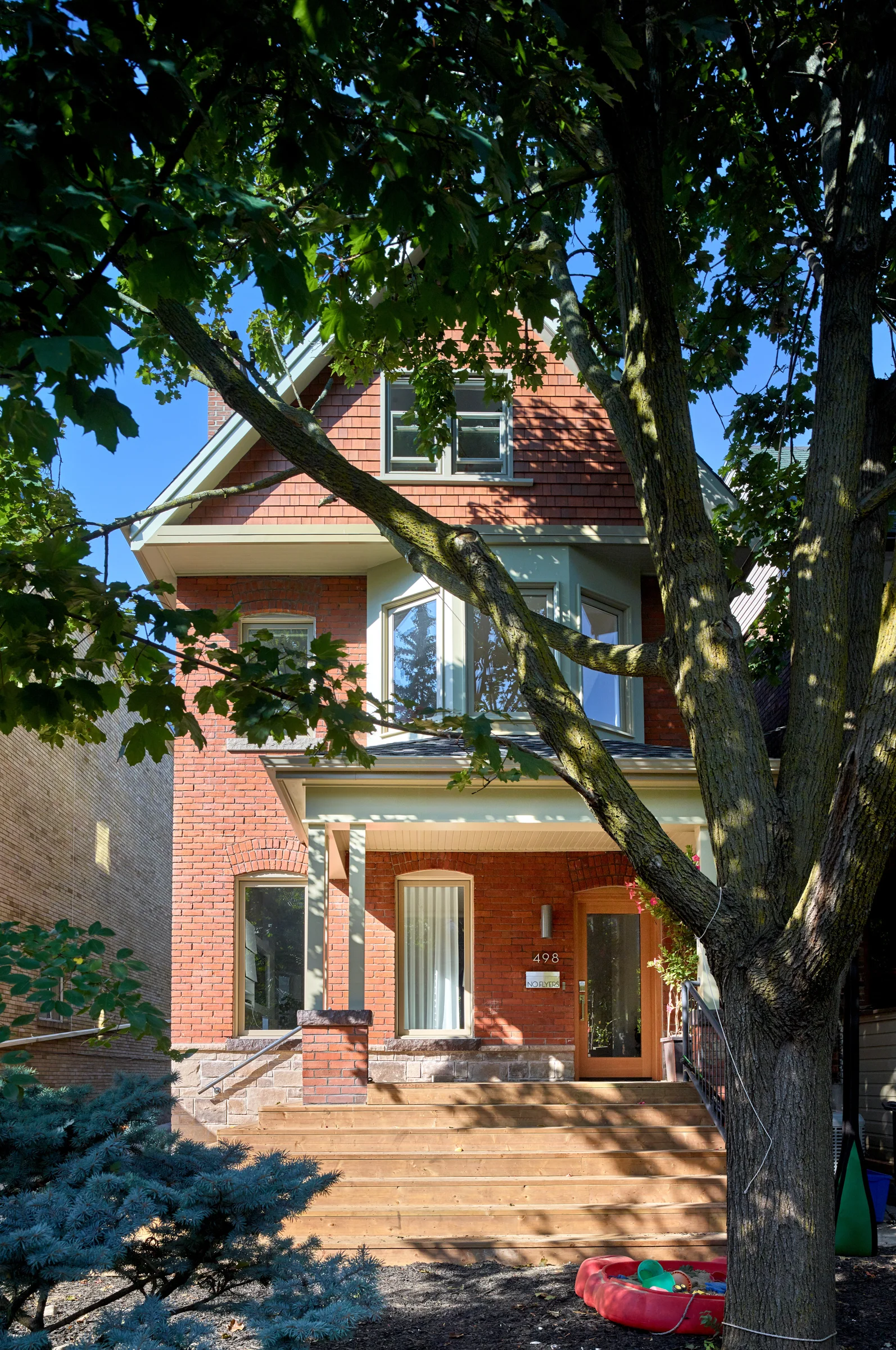 The front of the house upholds the neighbourhood’s traditional Edwardian character but with a few modern touches and a refined palette of cedar shakes and a crisply re-constructed bay window.