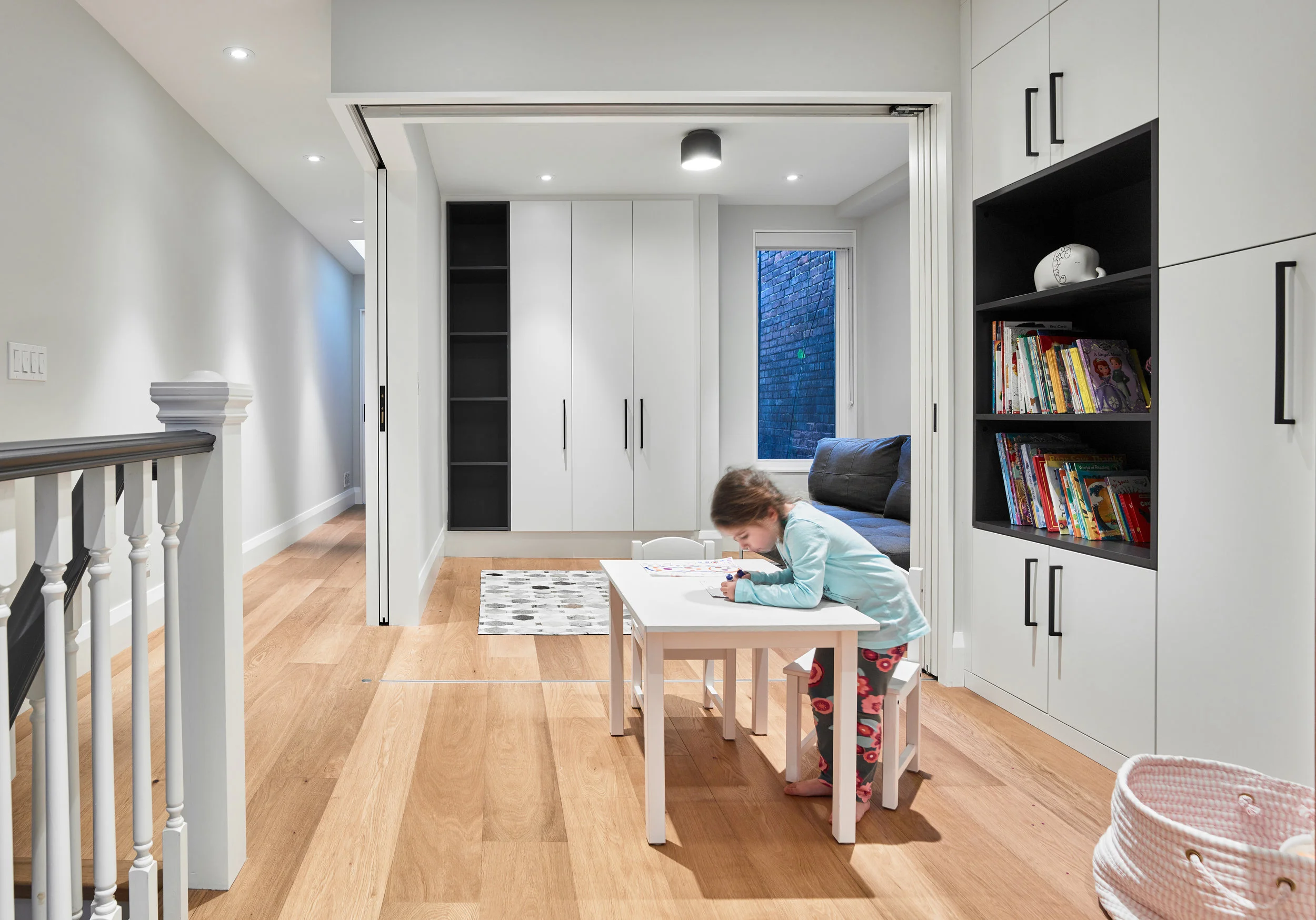 The client's request for both a larger family room and guest bedroom was resolved in the use of triple-folding doors, which allows for flexibility when a private room is needed for guests, as well as a large flex space that functions as a play room and den. 