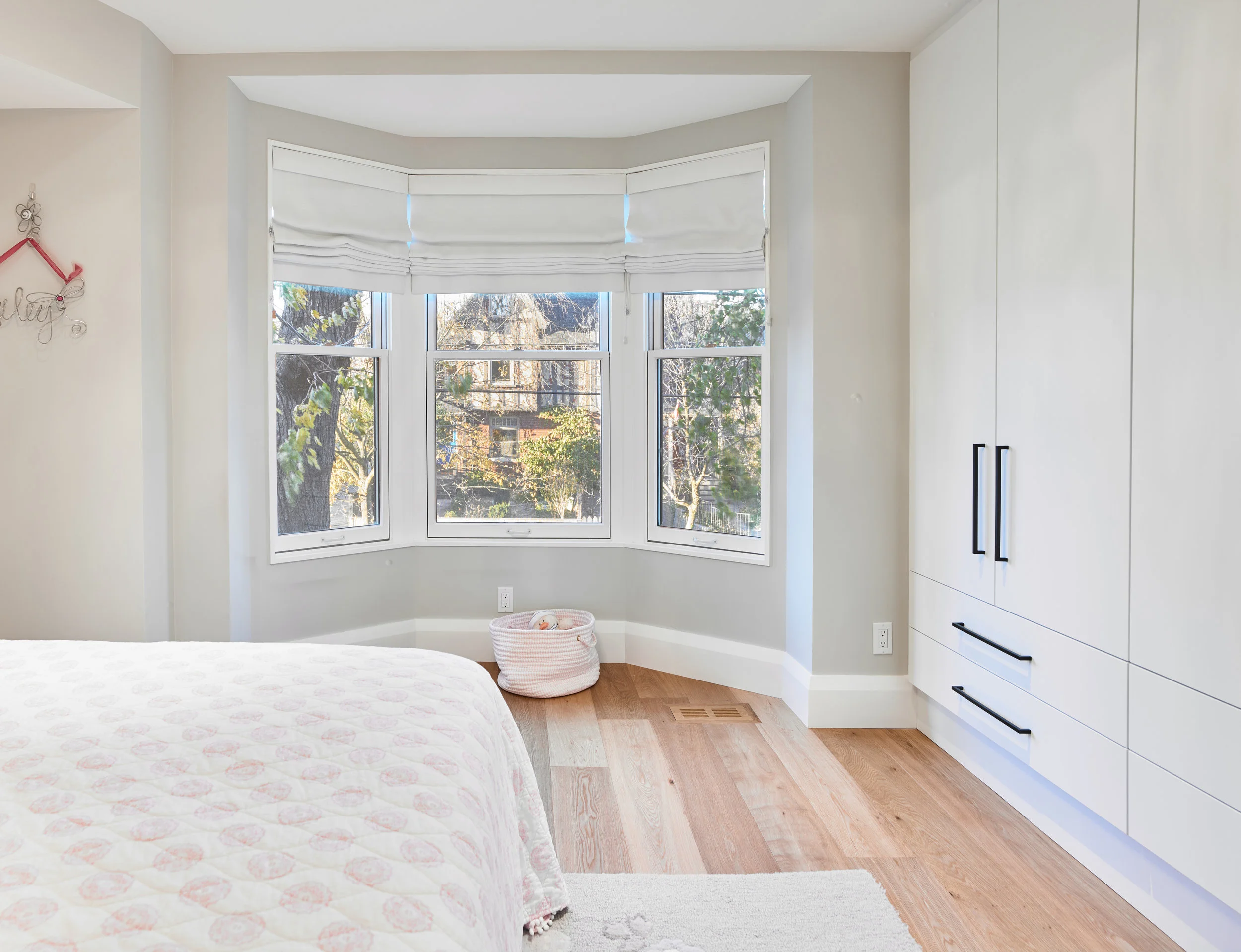 Built-in storage in the bedroom offers a better use of space, while allowing all of the natural light from the existing bay window to enter the room. 