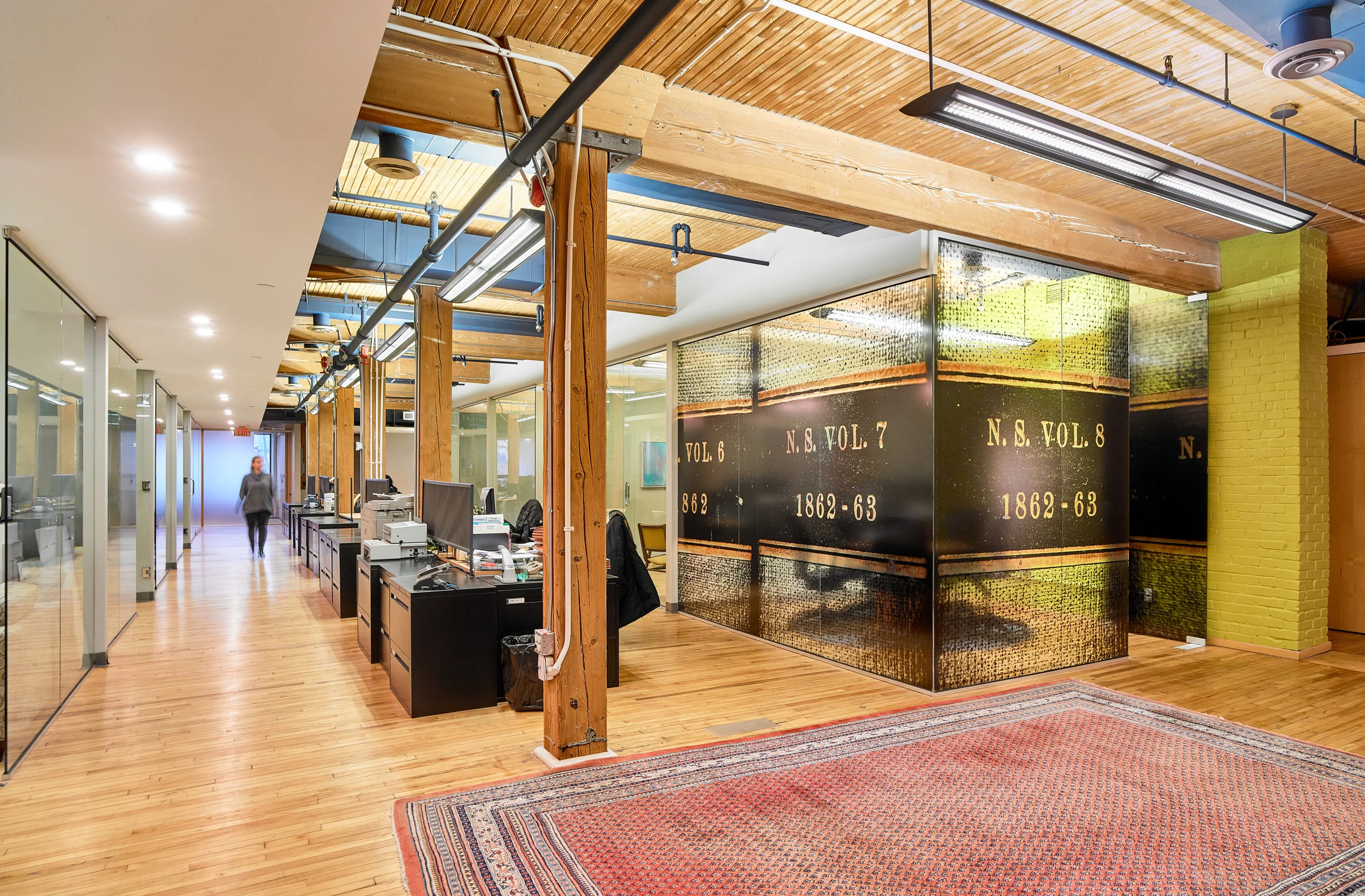 Open workstations are aligned to the heavy timber columns whereas closed spaces line the perimeter, creating an interior streetscape. Common meeting rooms are treated with a custom graphic film, like the conference room, to distinguish them from individual offices.